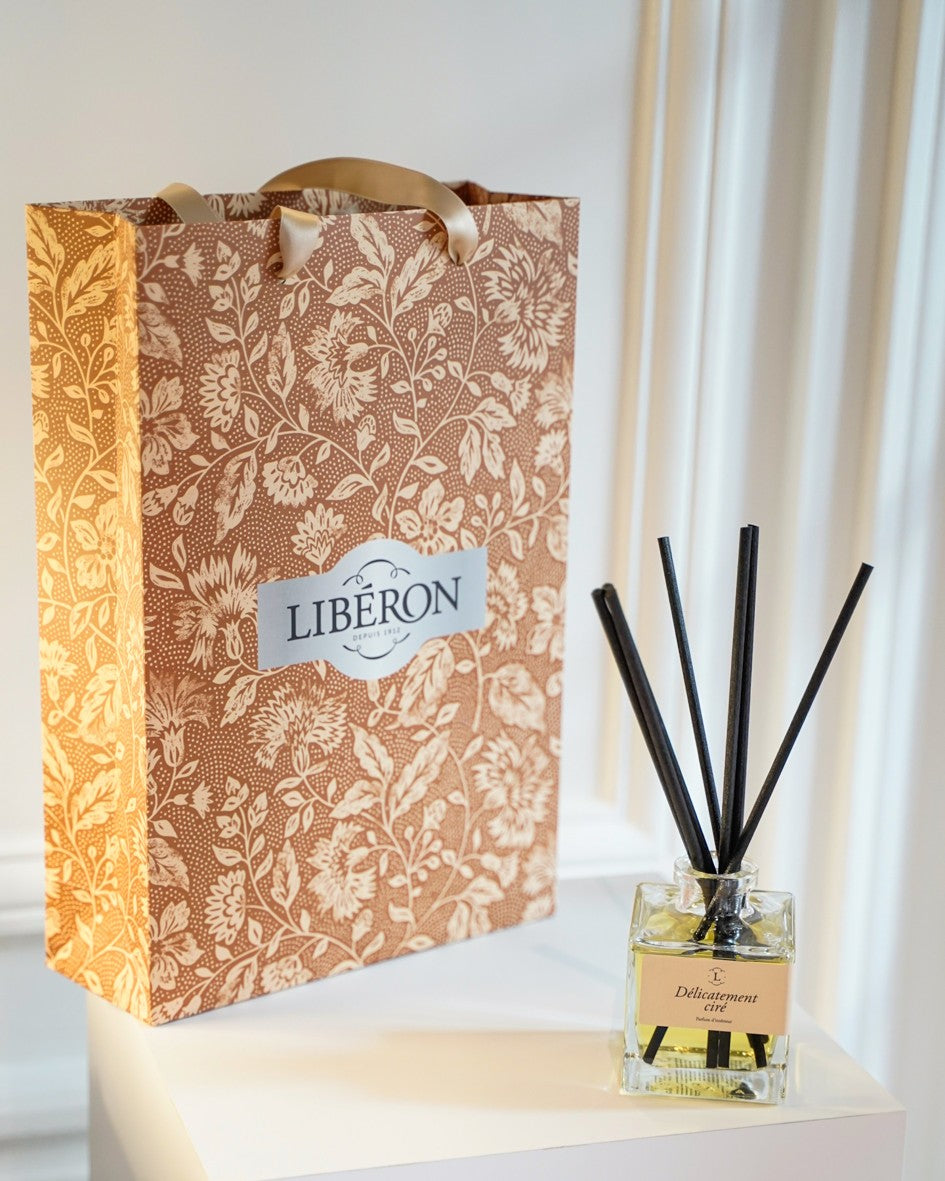 Sac cadeau Libéron au motif floral avec diffuseur de parfum Délicatement ciré sur socle blanc.