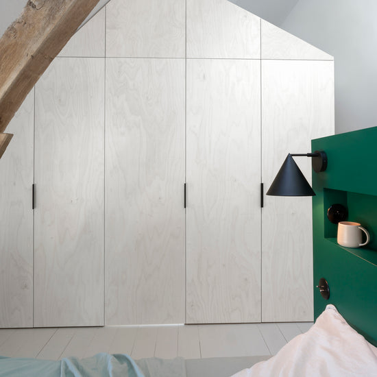 Ambiance chambre avec portes de placard décorées avec le Badigeon teinte Blanc Coton, murs blancs et tête de lit verte 