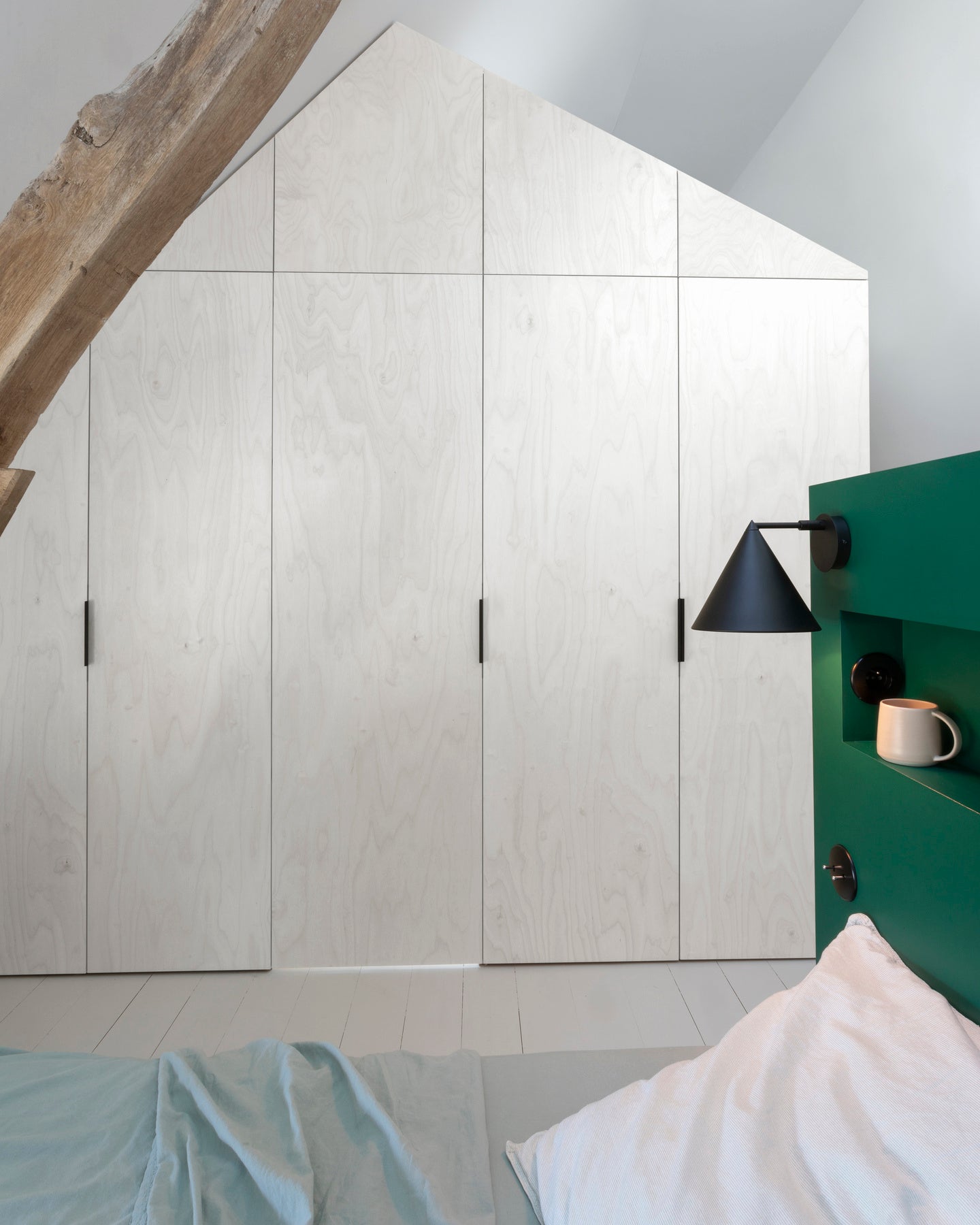 Ambiance chambre avec portes de placard décorées avec le Badigeon teinte Blanc Coton, murs blancs et tête de lit verte 