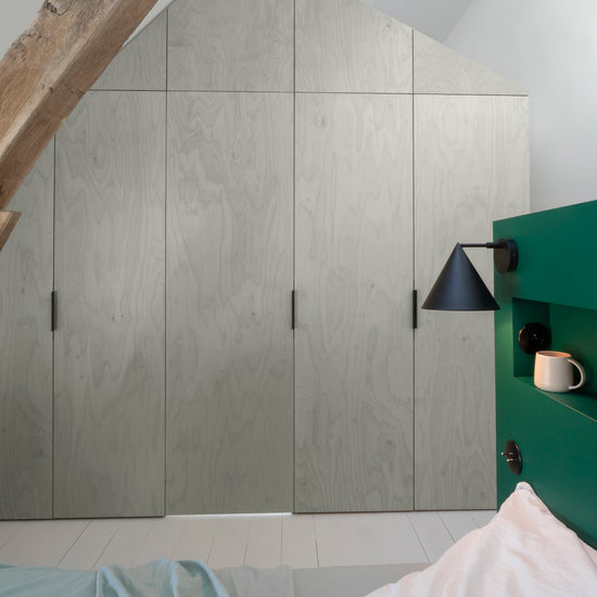 Ambiance chambre avec portes de placard décorées avec le Badigeon teinte Brume, murs blancs et tête de lit verte 