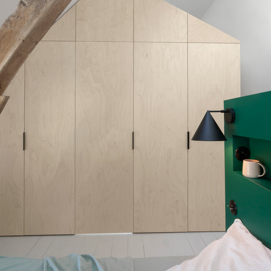 Ambiance chambre avec portes de placard décorées avec le Badigeon teinte Ficelle, murs blancs et tête de lit verte