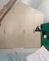 Ambiance chambre avec portes de placard décorées avec le Badigeon teinte Ficelle, murs blancs et tête de lit verte