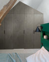 Ambiance chambre avec portes de placard décorées avec le Badigeon teinte Gris Fusain, murs blancs et tête de lit verte