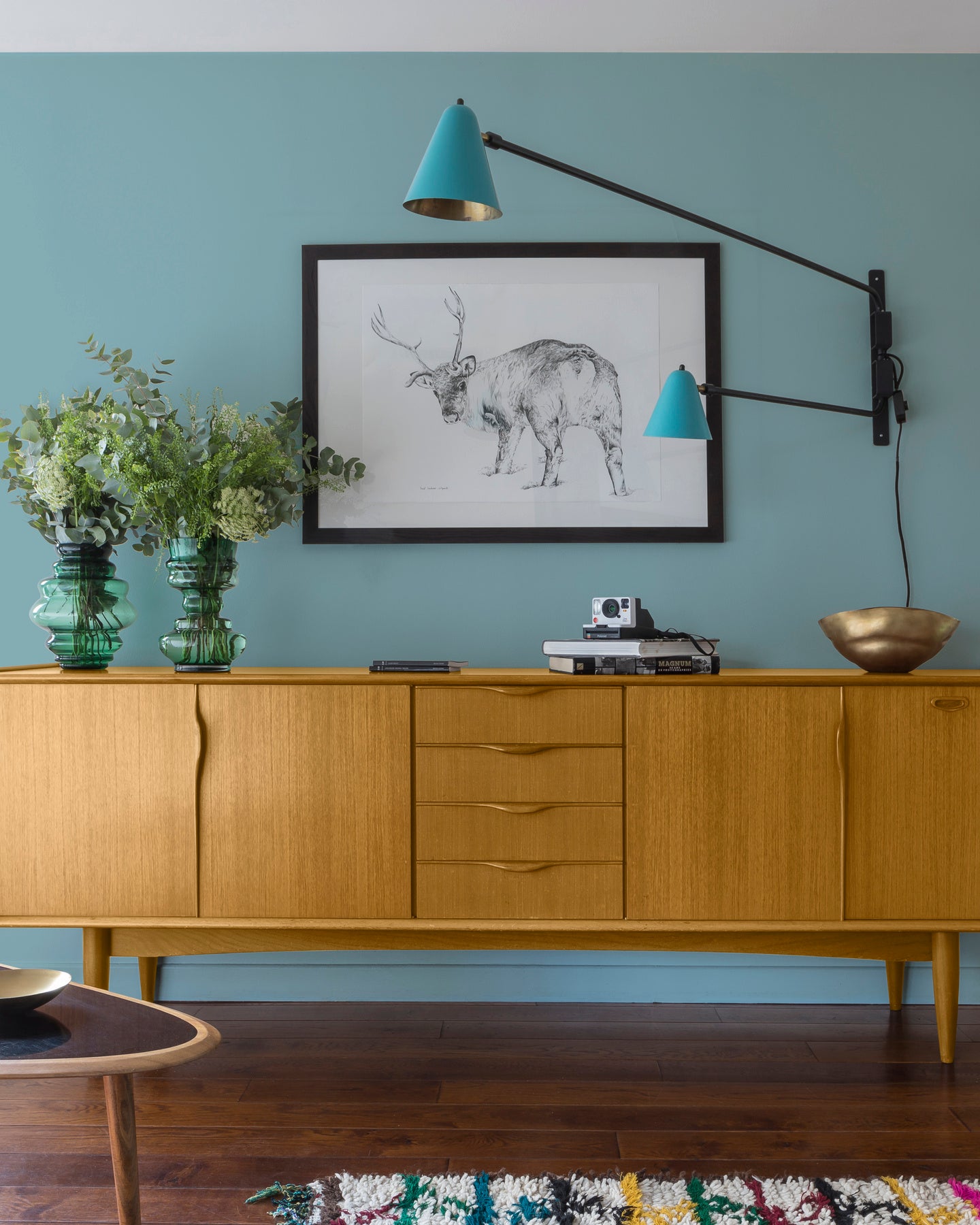 Buffet en bois ciré avec la Cire Black Bison Chêne Clair Libéron, dans un salon lumineux, avec vases verts, appliques bleues et déco vintage Libéron.