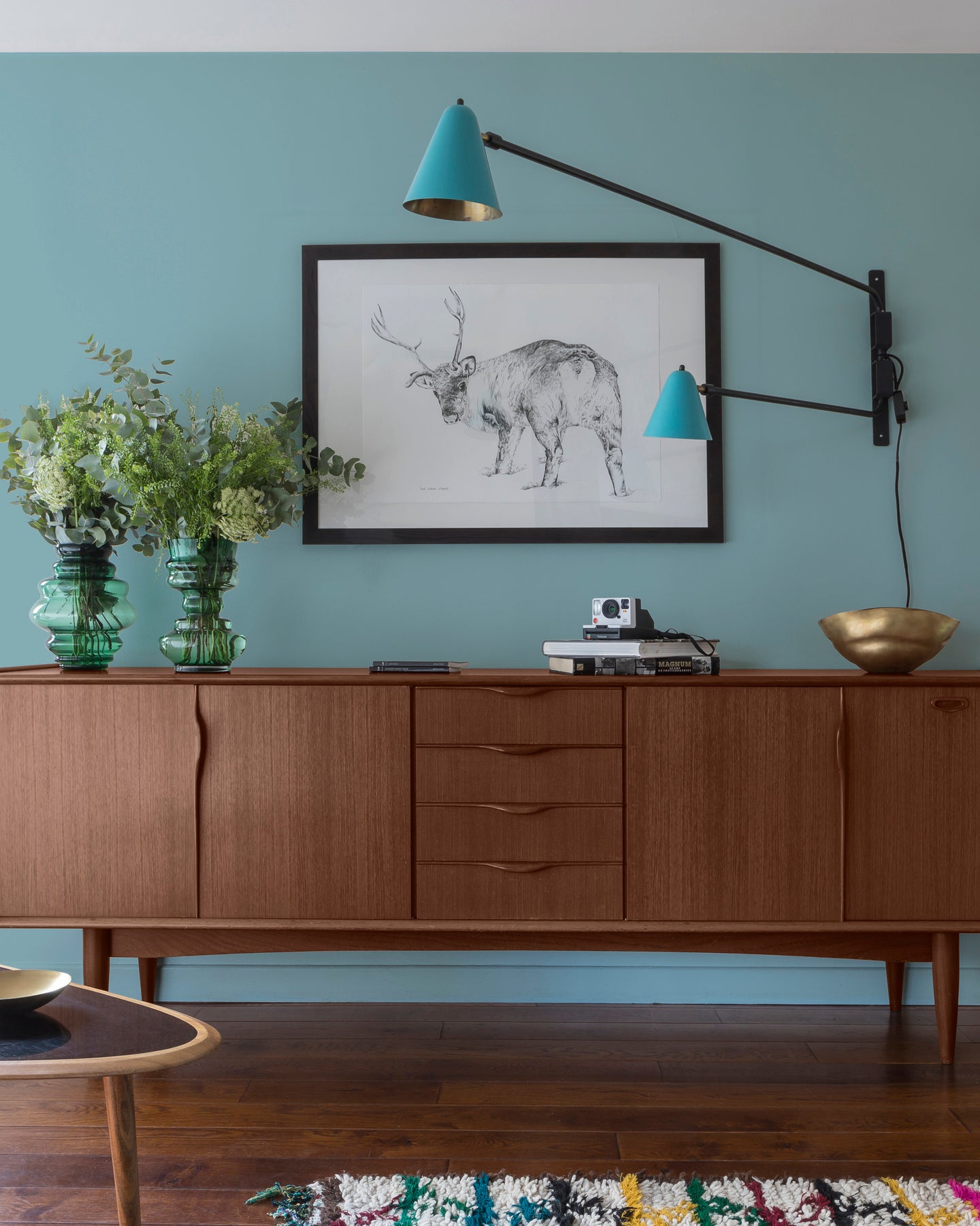 Buffet en bois ciré avec la Cire Black Bison Chêne Foncé Libéron, dans un salon lumineux, avec vases verts, appliques bleues et déco vintage Libéron.