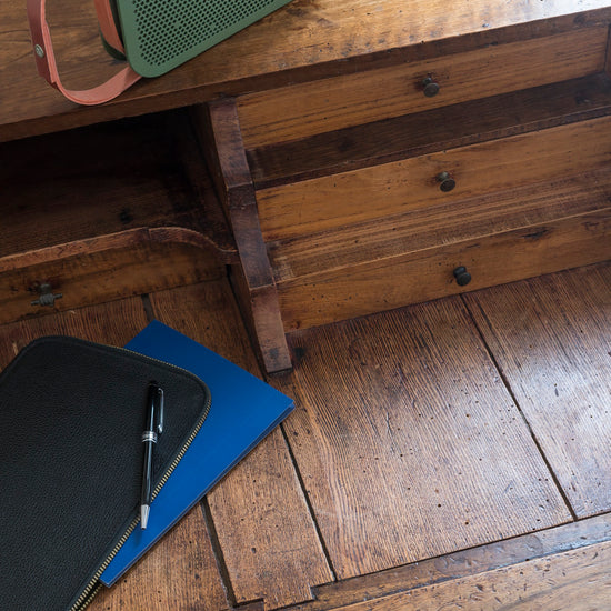 Bureau avec tiroirs en bois ciré avec la Cire Black Bison Chêne Foncé Libéron, avec cahier bleu et enceinte verte