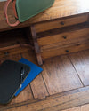 Bureau avec tiroirs en bois ciré avec la Cire Black Bison Chêne Foncé Libéron, avec cahier bleu et enceinte verte