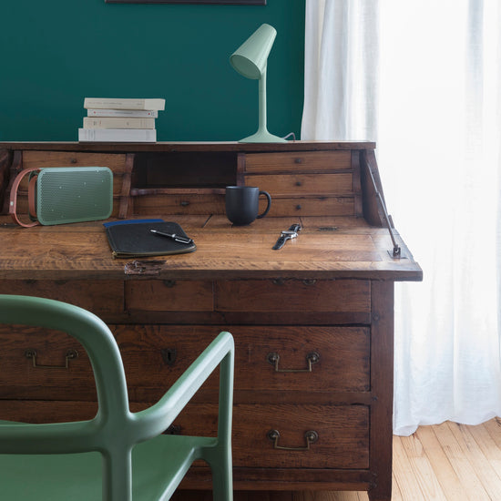 Coin bureau ciré avec la Cire Antiquaire Black Bison teinte Chêne Foncé Libéron, murs peints avec Velours de Peinture Vert au Tableau, lampe, chaise et enceinte vertes.