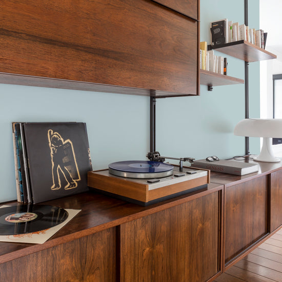 Buffet en bois ciré avec la Cire Black Bison Chêne Moyen Libéron, dans un salon lumineux, avec une platine, des vinyles, des livres et une lampe.