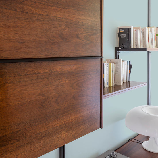 Buffet en bois ciré avec la Cire Black Bison Chêne Moyen Libéron, dans un salon lumineux, avec étagères et livres, et une lampe.