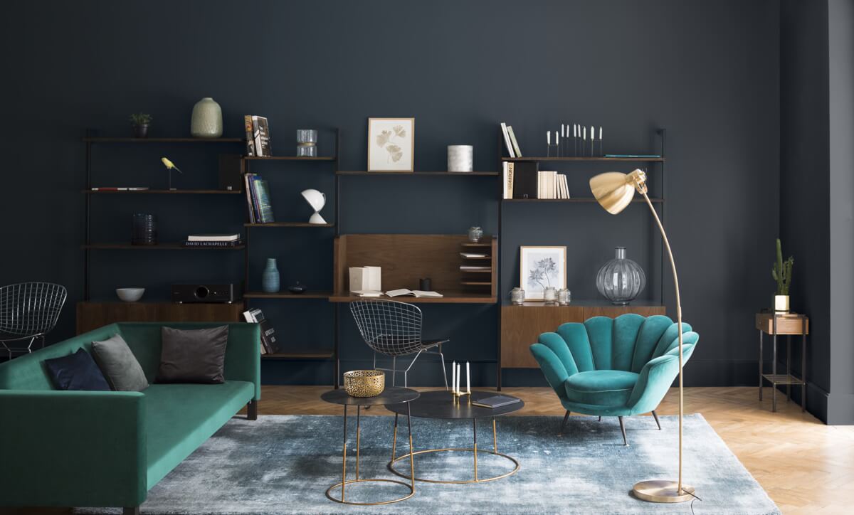 Salon aux murs gris et noirs Libéron Velours de Peinture, avec canapé vert, fauteuil bleu et mobilier bois.
