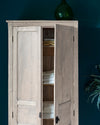 Armoire blanche cirée avec La Crème de Cire teinte Blanc Coton Libéron, murs bleu foncé, vase vert et plante