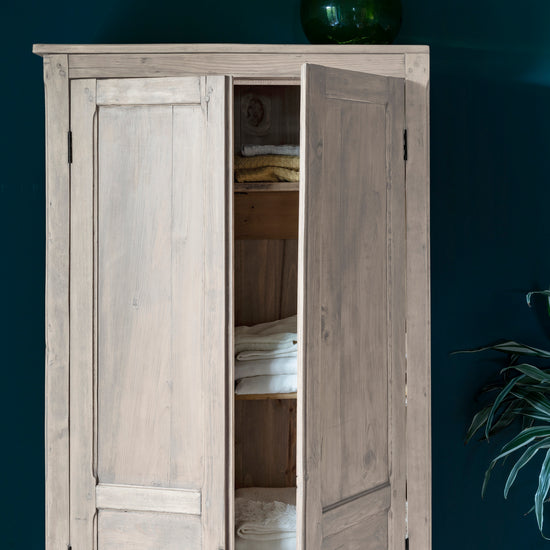 Armoire cirée avec La Crème de Cire teinte Blanc Libéron, murs bleu foncé, vase vert et plante