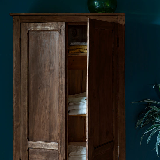 Armoire cirée avec La Crème de Cire teinte Chêne Cendré Libéron, murs bleu foncé, vase vert et plante