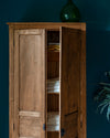Armoire cirée avec La Crème de Cire teinte Chêne Doré Libéron, murs bleu foncé, vase vert et plante