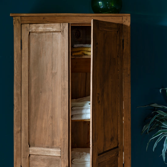 Armoire cirée avec La Crème de Cire teinte Chêne Doré Libéron, murs bleu foncé, vase vert et plante