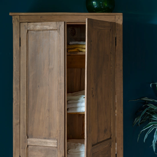 Armoire cirée avec La Crème de Cire teinte Incolore Libéron, murs bleu foncé, vase vert et plante