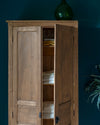 Armoire cirée avec La Crème de Cire teinte Incolore Libéron, murs bleu foncé, vase vert et plante