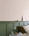 Chambre avec papier peint Velours de Papier Florette Libéron, soubassement vert sauge, lampe grise et linge naturel.