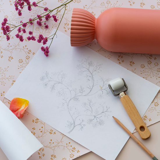 Détail de papier peint floral Belle Jeanne Libéron, avec vase corail, fleurs roses, dessin botanique et petit rouleau.