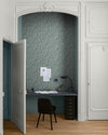 Coin bureau aux murs bleu grisé, Velours de Peinture Libéron Oeillet de reine, avec papier peint fleuri, chaise noire et porte blanche.