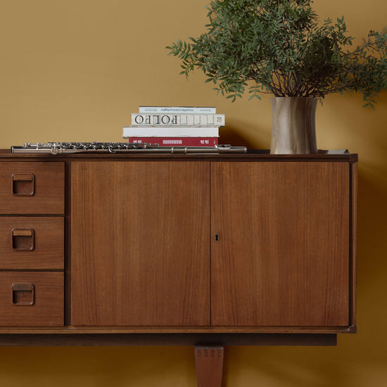 Salon aux murs jaunes et commode huilée avec l'Huile Soin Libéron, avec plantes vertes et livres