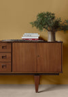 Salon aux murs jaunes et commode huilée avec l'Huile Soin Libéron, avec plantes vertes et livres