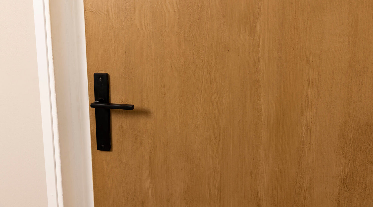 Porte effet bois clair Libéron après peinture, avec veinage visible et poignée noire.