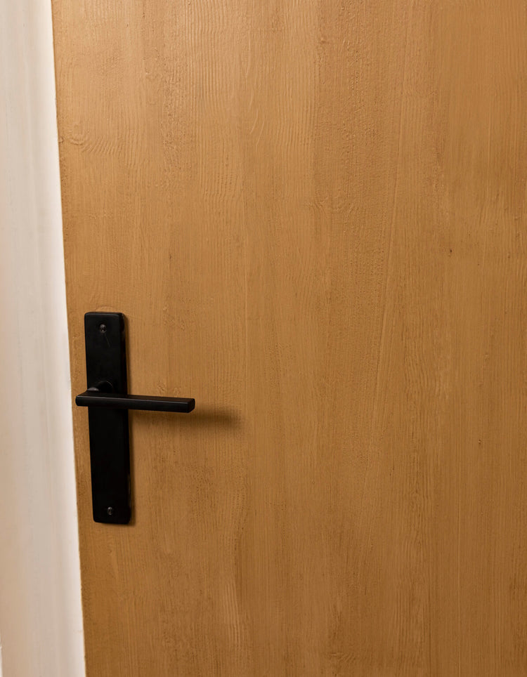 Porte effet bois clair Libéron après peinture, avec veinage visible et poignée noire.
