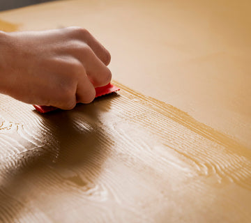 Création d’un veinage effet bois Libéron avec un outil décoratif sur une surface peinte beige.