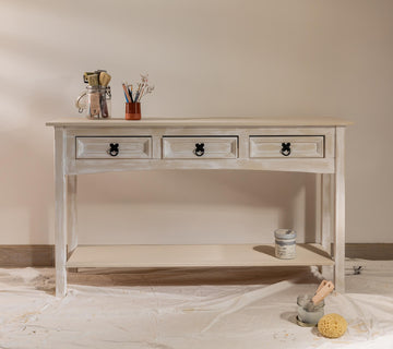 Console effet chaulé Libéron avec tiroirs patinés, pot Meuble signé et accessoires dans une ambiance atelier.