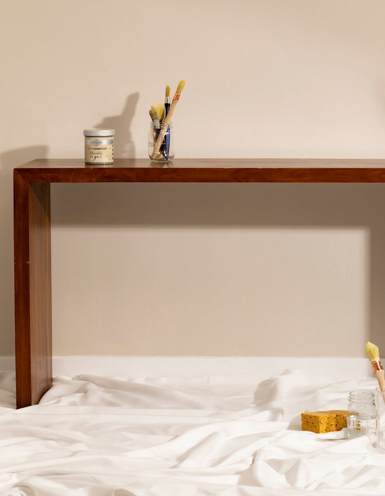 Console en bois avant peinture effet minéral Libéron, avec pot Meuble signé, pinceaux et éponge sur drap blanc.