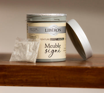 Pot Libéron Meuble signé Peinture effet minéral avec sachet de poudre et couvercle, posé sur du bois.