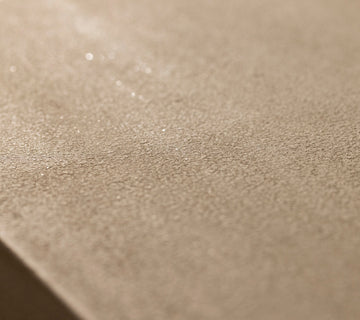 Détail de surface effet minéral beige Libéron, avec texture mate légèrement scintillante.