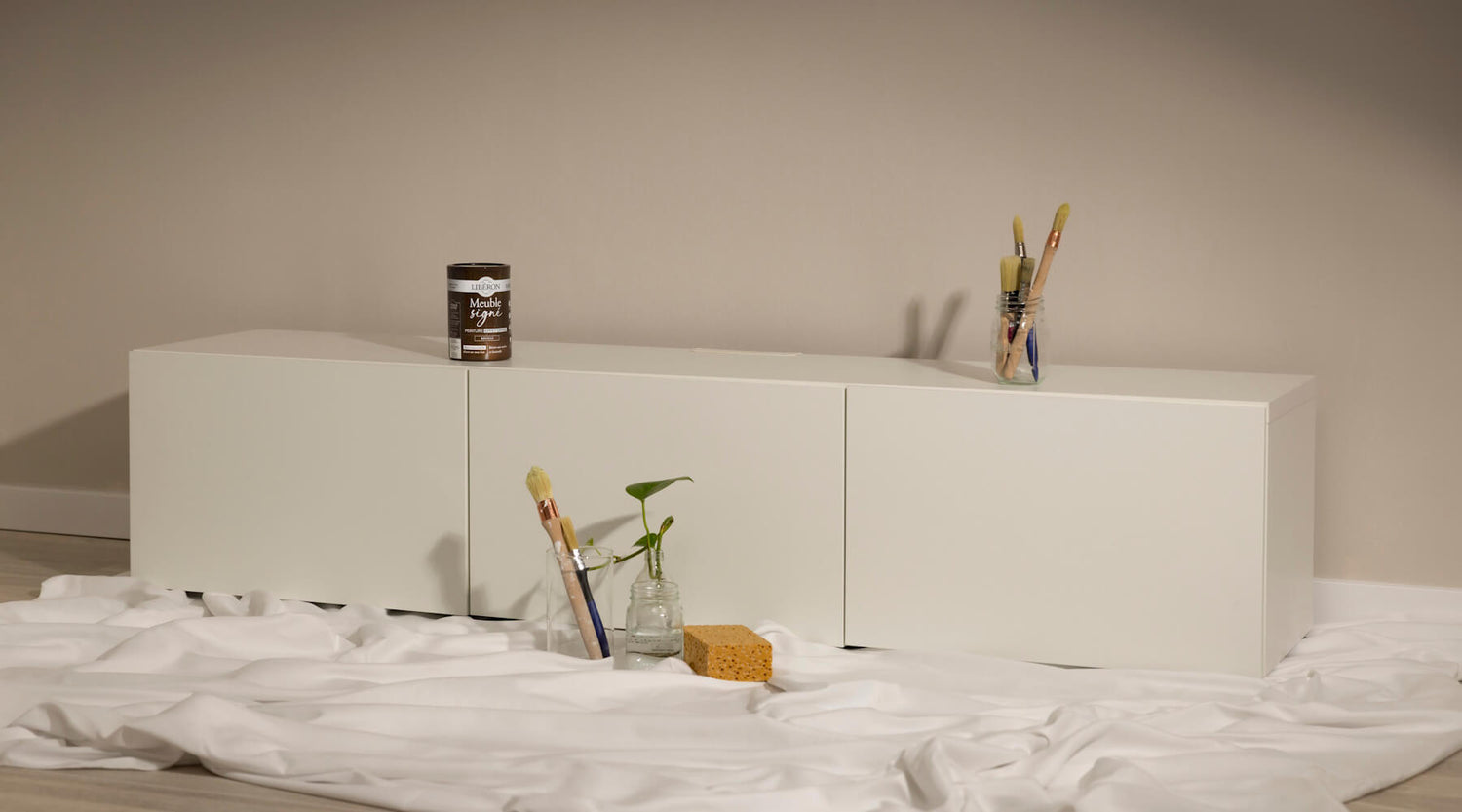 Meuble bas blanc avant effet oxyde Libéron, avec pot Meuble signé, pinceaux, éponge et toile de protection.