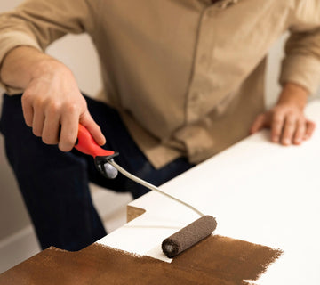Application au rouleau de peinture effet oxyde Libéron sur un meuble blanc en cours de rénovation.