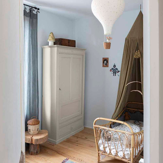 Ambiance d'une chambre d'enfant aux murs bleu, avec armoire blanc, peinture Meuble Signé Mat à base de Caséine teinte Blanc Plume Libéron