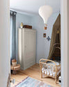 Ambiance d'une chambre d'enfant aux murs bleu, avec armoire blanc, peinture Meuble Signé Mat à base de Caséine teinte Blanc Plume Libéron
