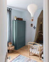Ambiance d'une chambre d'enfant aux murs bleu, avec armoire beige, peinture Meuble Signé Mat à base de Caséine teinte Bleu Sarcelle Libéron