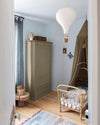 Ambiance d'une chambre d'enfant aux murs bleu, avec armoire beige, peinture Meuble Signé Mat à base de Caséine teinte Bord de Seine Libéron