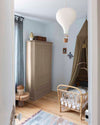 Ambiance d'une chambre d'enfant aux murs bleu, avec armoire beige, peinture Meuble Signé Mat à base de Caséine teinte Champignon Libéron