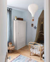 Ambiance d'une chambre d'enfant aux murs bleu, avec armoire blanche, peinture Meuble Signé Mat à base de Caséine teinte Crème Libéron