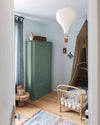 Ambiance d'une chambre d'enfant aux murs bleu, avec armoire verte, peinture Meuble Signé Mat à base de Caséine teinte Eucalyptus Libéron