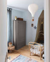 Ambiance d'une chambre d'enfant aux murs bleu, avec armoire grise, peinture Meuble Signé Mat à base de Caséine teinte Feutrine Libéron