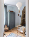 Ambiance d'une chambre d'enfant aux murs bleu, avec armoire grise, peinture Meuble Signé Mat à base de Caséine teinte Gris Gustavien Libéron