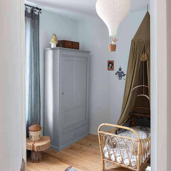 Ambiance d'une chambre d'enfant aux murs bleu, avec armoire grise, peinture Meuble Signé Mat à base de Caséine teinte Gris Nuée Libéron