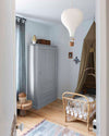 Ambiance d'une chambre d'enfant aux murs bleu, avec armoire grise, peinture Meuble Signé Mat à base de Caséine teinte Gris Nuée Libéron