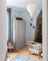 Ambiance d'une chambre d'enfant aux murs bleu, avec armoire grise, peinture Meuble Signé Mat à base de Caséine teinte Gris Perle Libéron