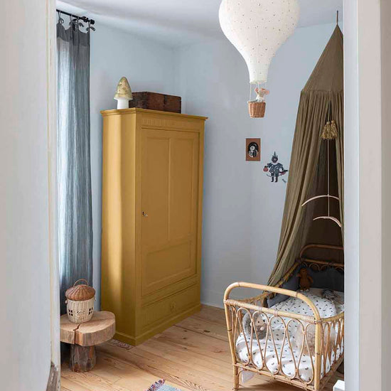 Ambiance d'une chambre d'enfant aux murs bleu, avec armoire jaune, peinture Meuble Signé Mat à base de Caséine teinte Miel Ambré Libéron