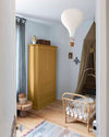 Ambiance d'une chambre d'enfant aux murs bleu, avec armoire jaune, peinture Meuble Signé Mat à base de Caséine teinte Miel Ambré Libéron